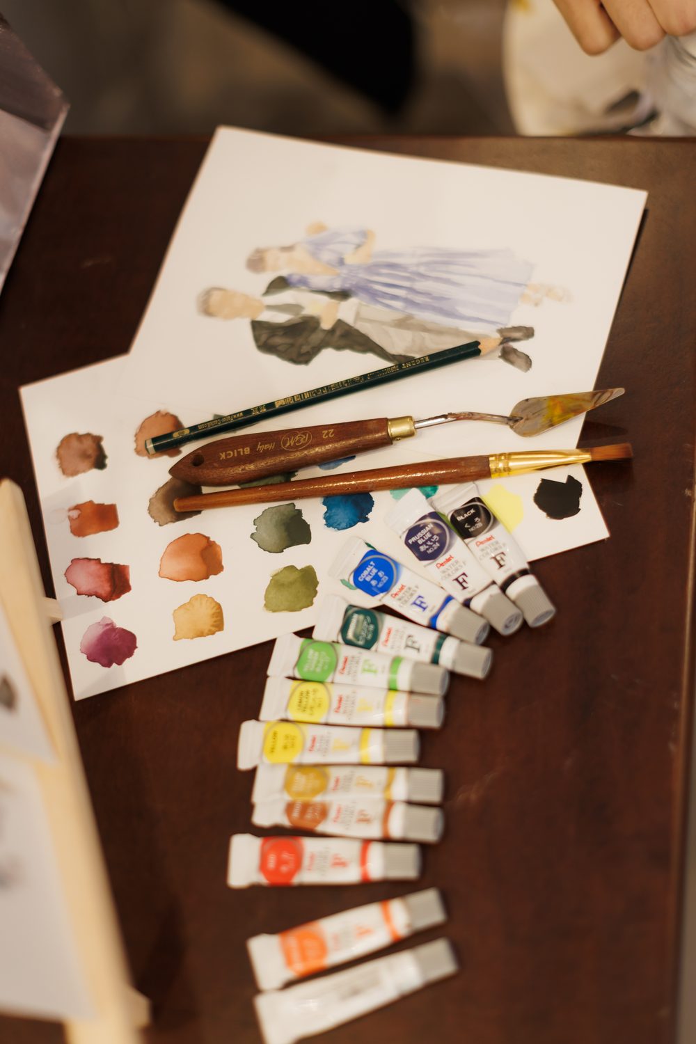 Tubos de aquarela, pincéis e paleta sobre a mesa